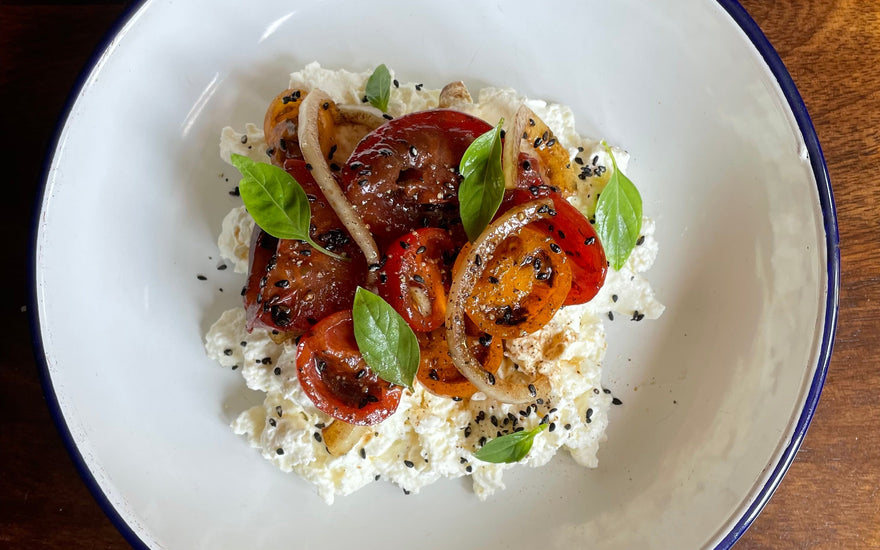 Homemade fresh cheese with tomato, lime and black garlic
